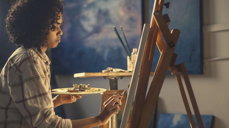Free Image of Female painter at easel painting in studio 