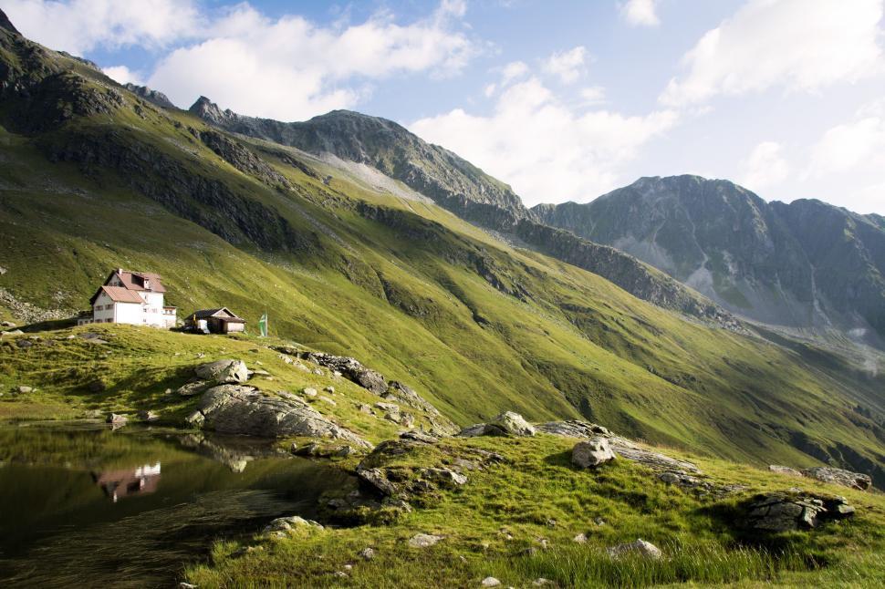 Free Image of Alpine house by a serene mountain lake 