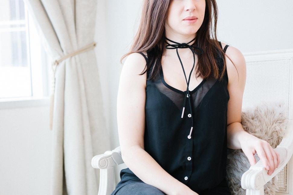 Free Image of Seated woman with blurred face wearing choker 