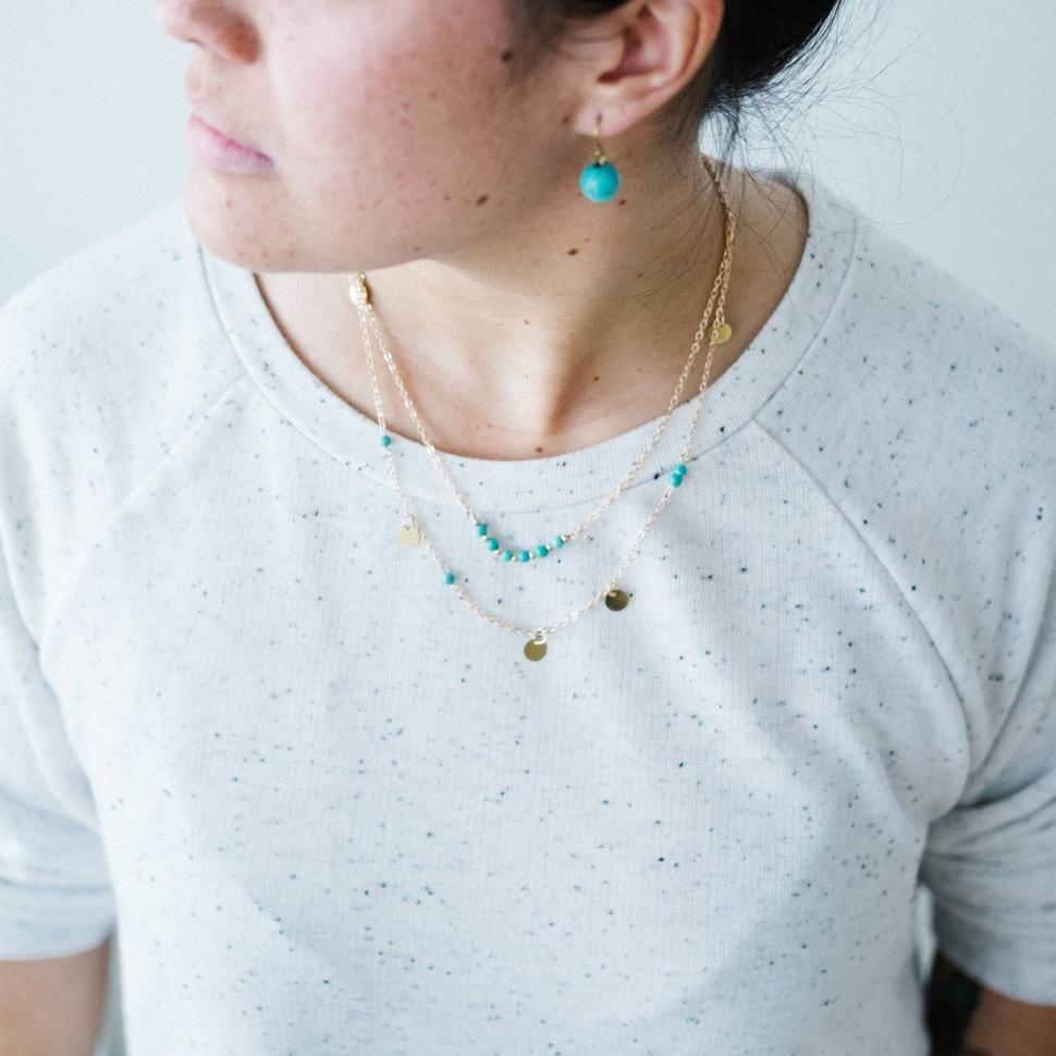 Free Image of Woman showcasing jewelry neutral backdrop 