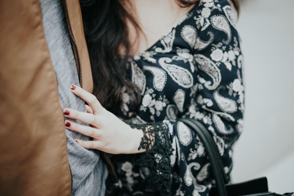 Free Image of Woman in floral dress holding onto man s arm 