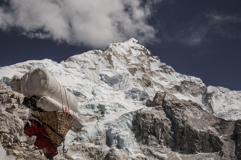 Free Image of Porter carrying a load on a mountain trek 