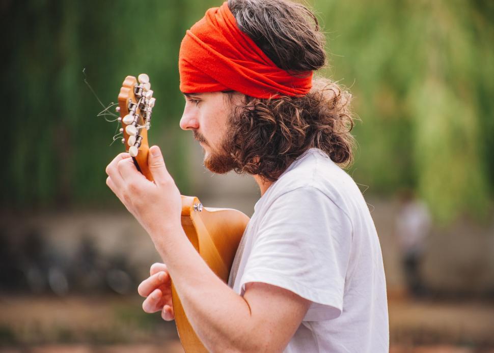 Free Image of Guitarist with bandana playing an acoustic guitar 