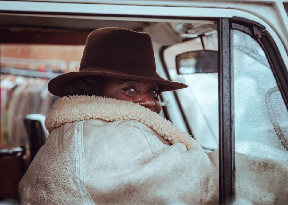 Free Image of Person with hat looking out of a car window 