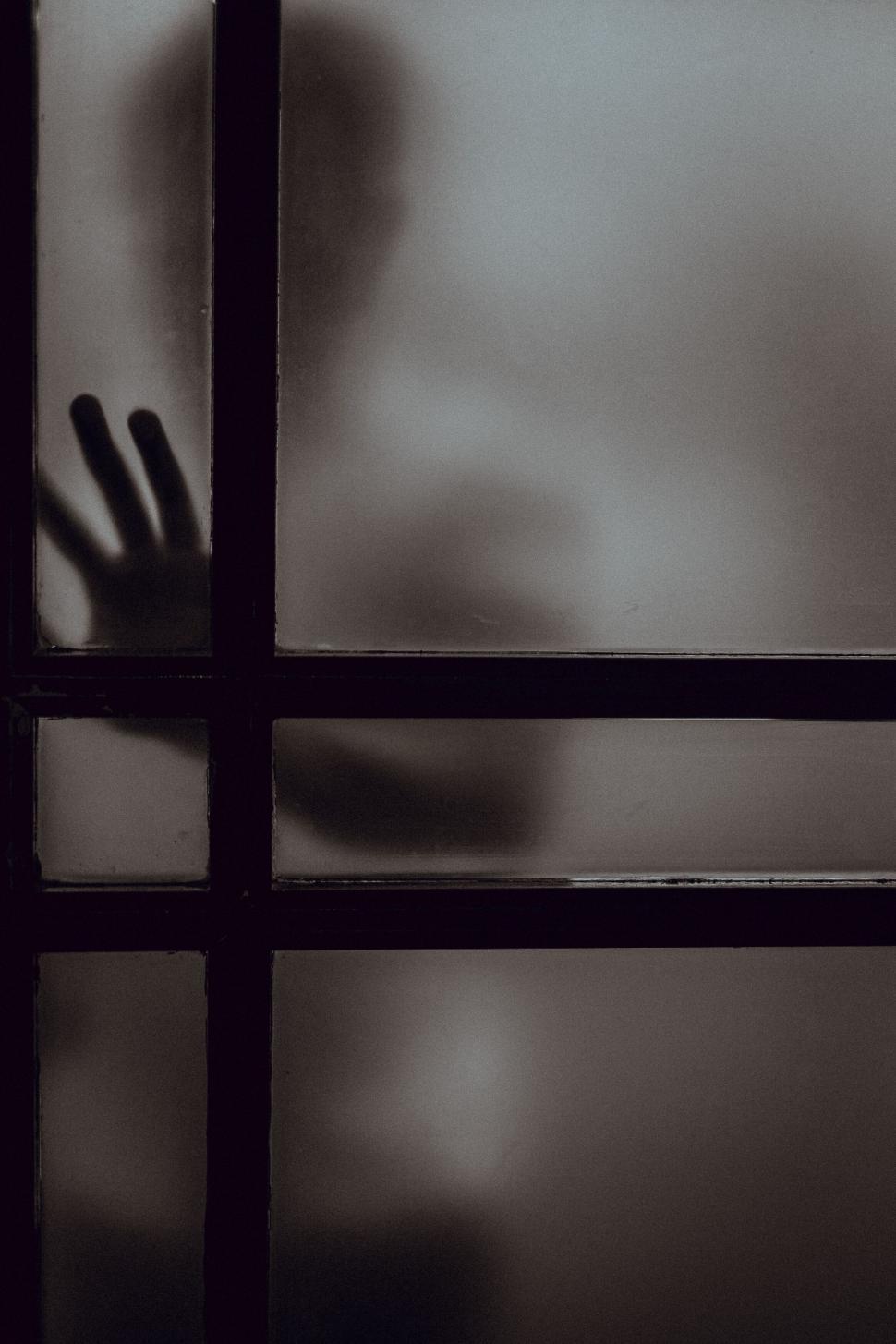 Free Image of Shadowy figure behind frosted glass window 