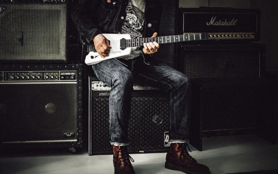 Free Image of Guitarist playing music on stage with amps 