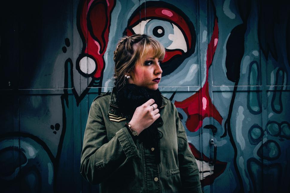Free Image of Woman standing against abstract art 