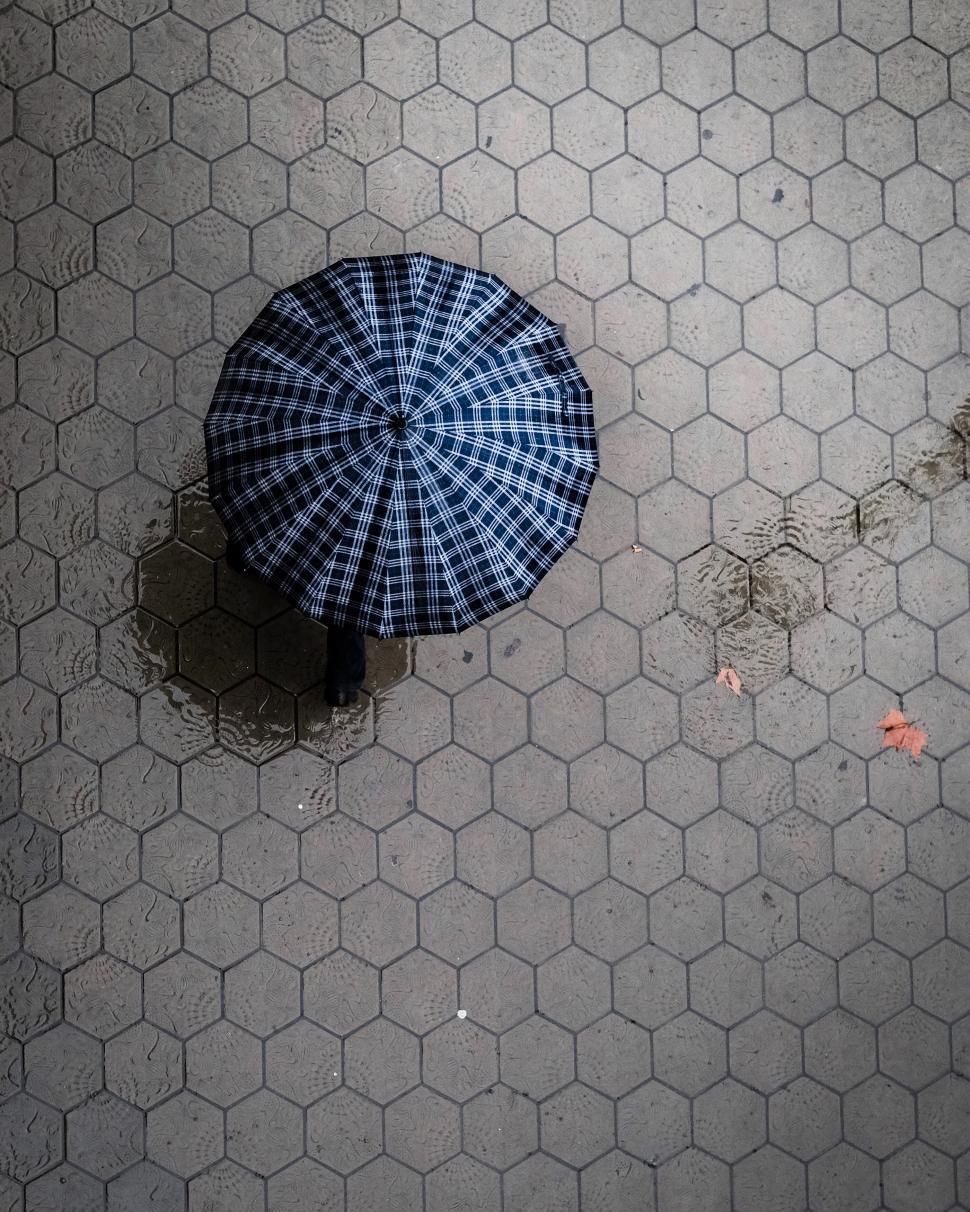 Free Image of Aerial view of a person with a checkered umbrella 