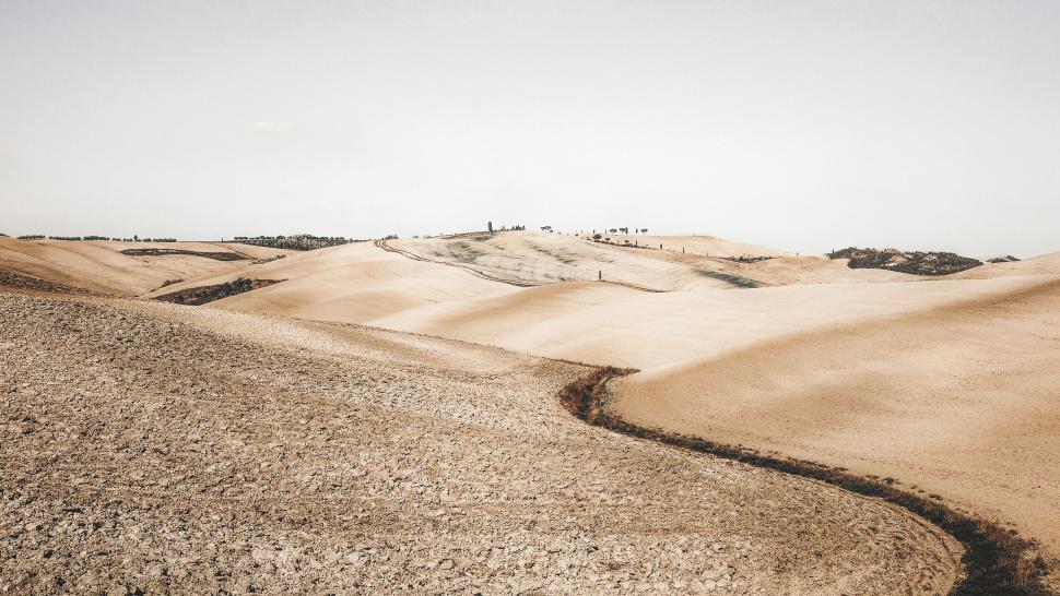 Free Image of Gentle hills with textured farmland under sky 