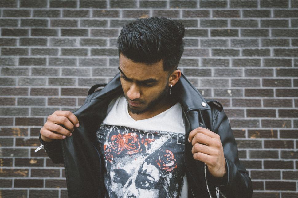 Free Image of Man in leather jacket against brick wall 