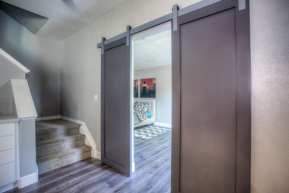 Free Image of Modern home with sliding barn doors to a room 