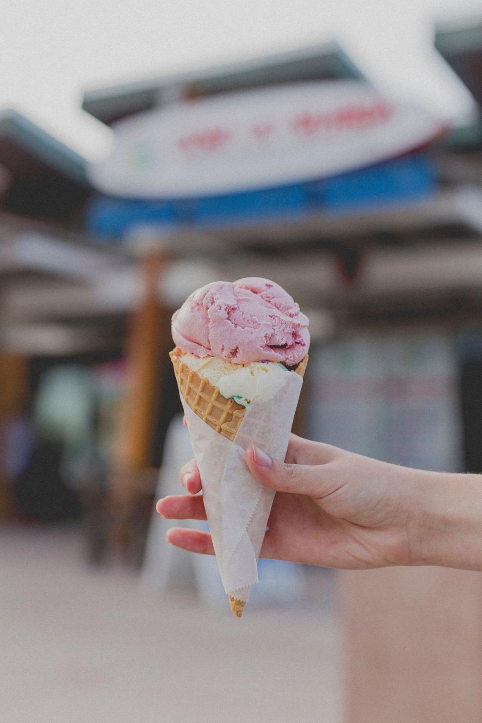 Free Image of Hand holding a melting ice cream cone 