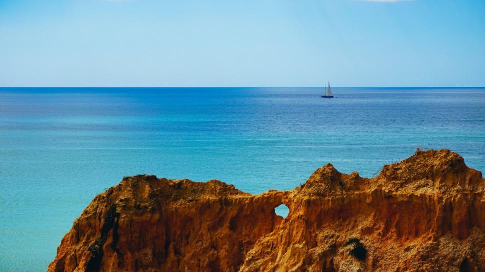 Free Image of Azure waters framed by rocky cliffs 