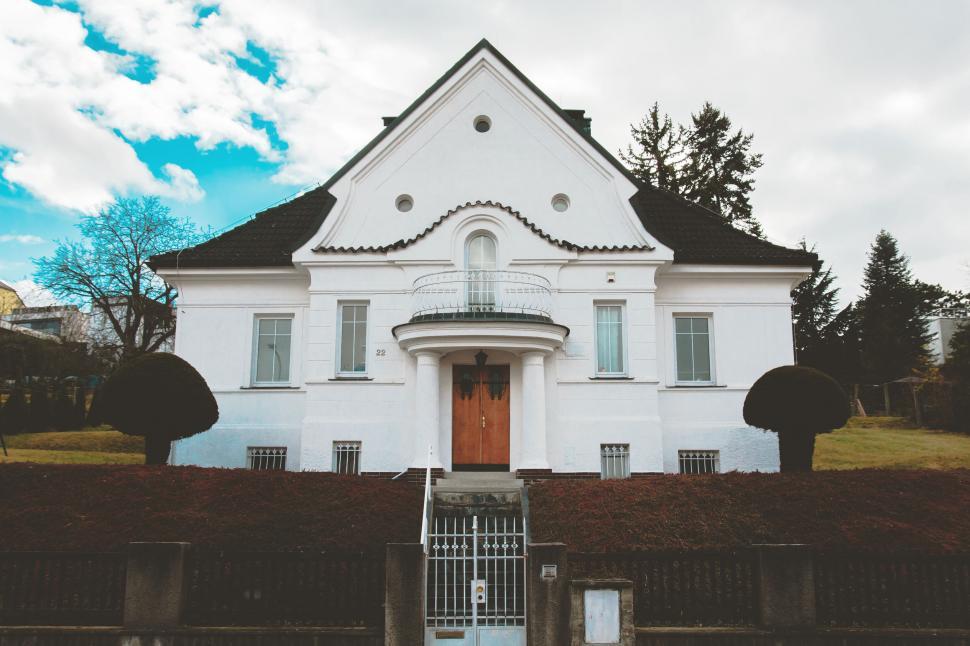 Free Image of Traditional white house with round bushes 