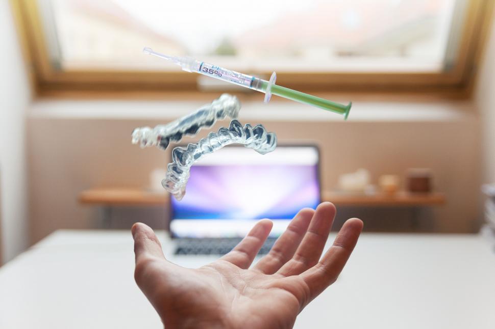 Free Image of Floating orthodontic retainer above open hand indoors 