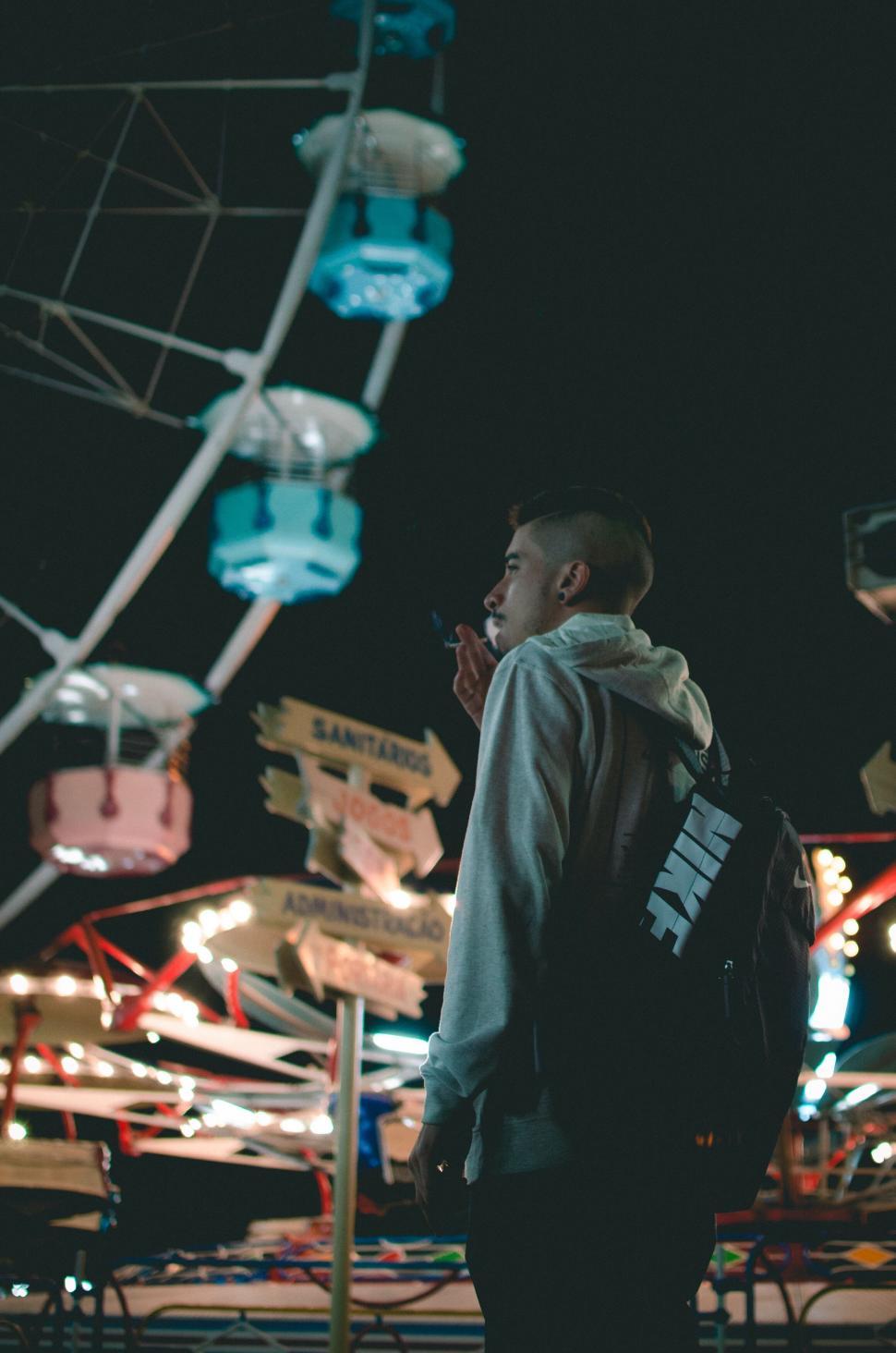 Free Image of Person standing in front of Ferris wheel 