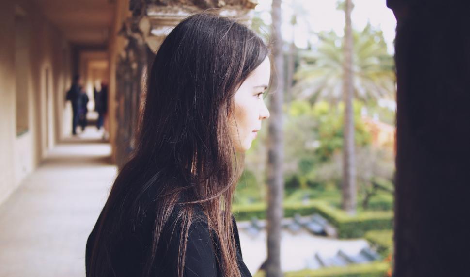 Free Image of Woman overlooking garden from historic arcade 