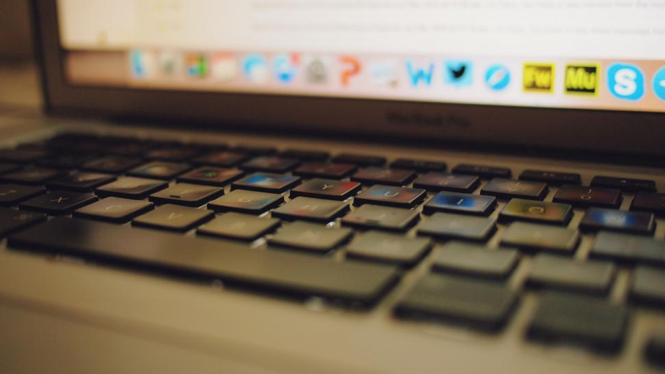 Free Image of Apple MacBook keyboard closeup with blurred icons 