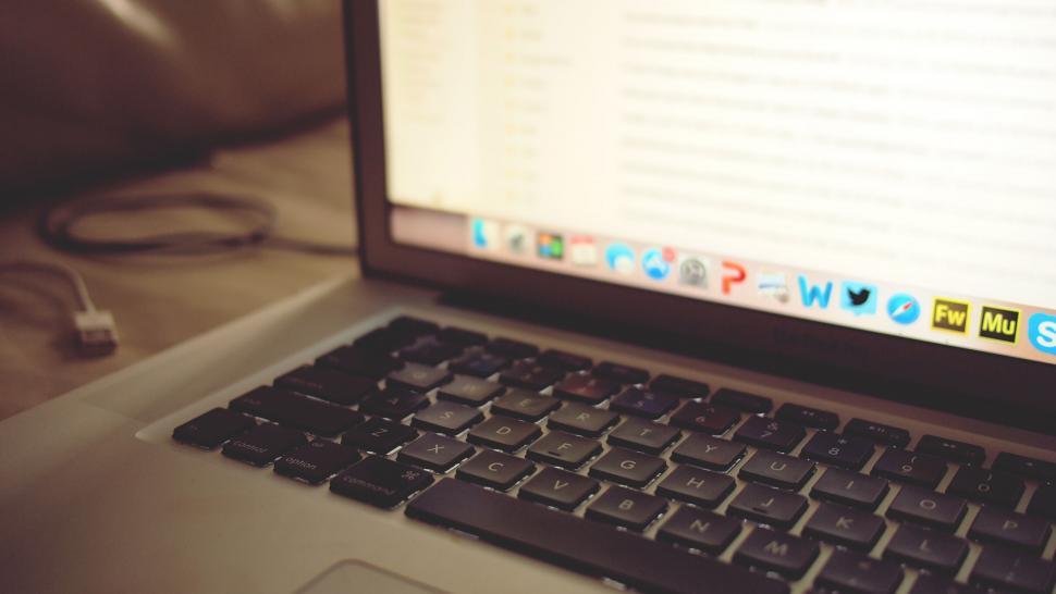 Free Image of Open laptop on a bed with focus on keyboard 