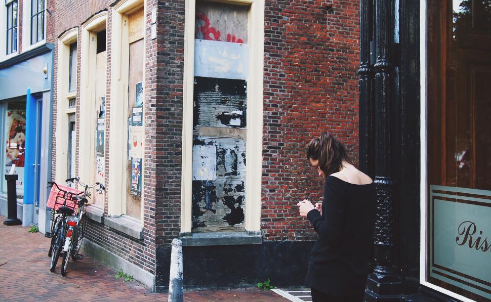 Free Image of Urban landscape with woman texting on phone 