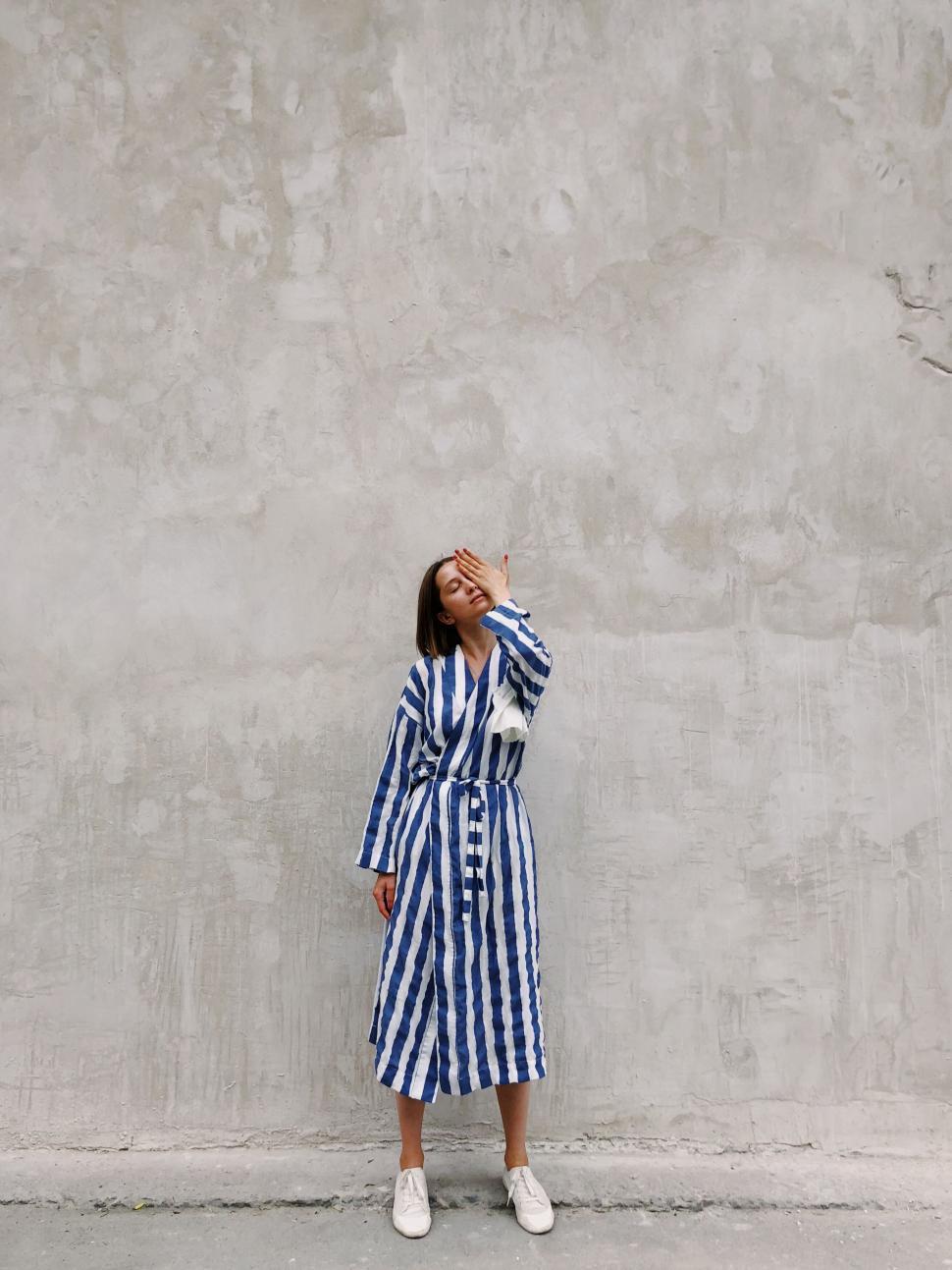 Free Image of Fashionable woman standing against textured wall 