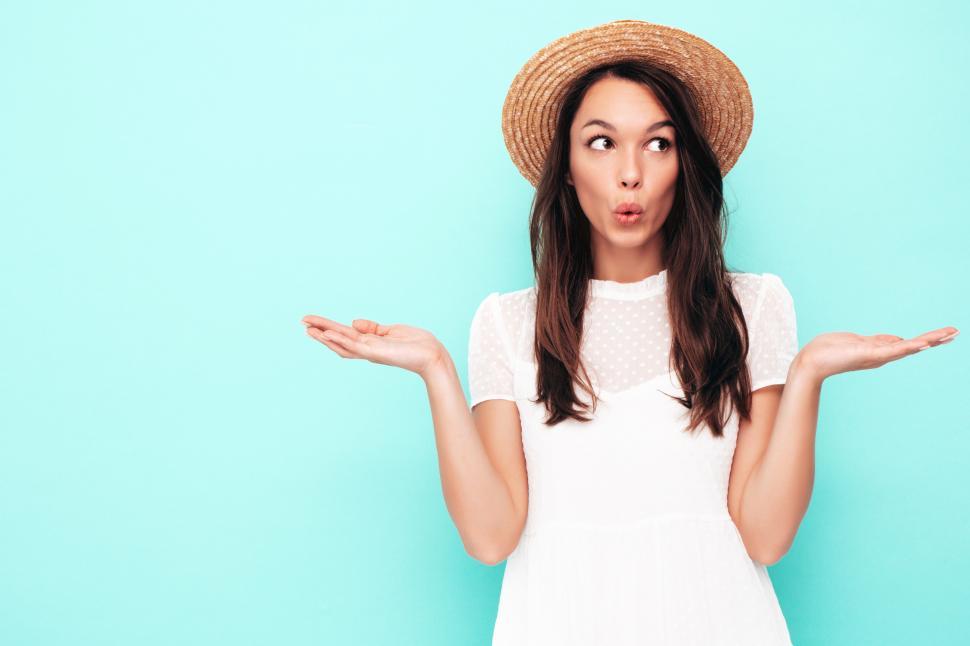 Free Image of A woman in a white dress and straw hat 