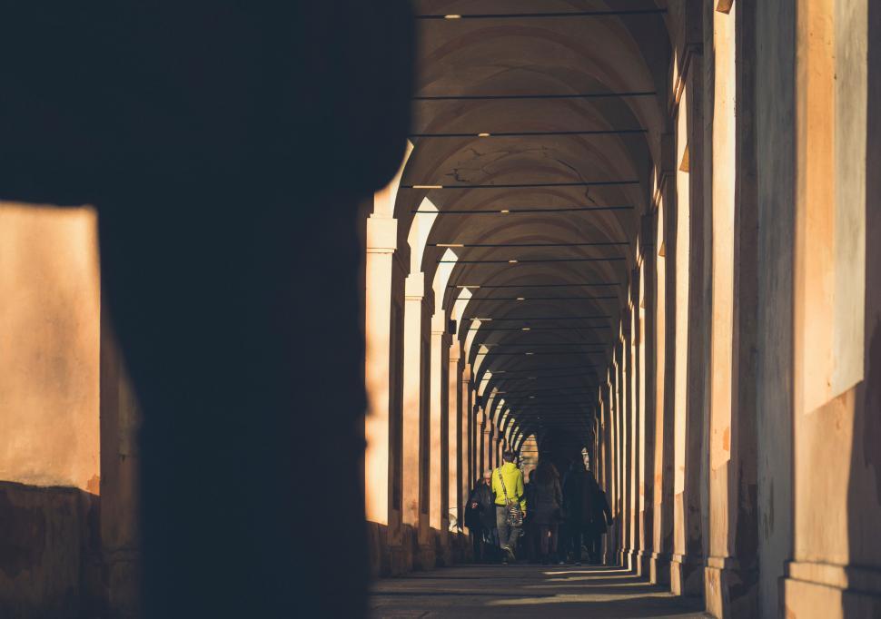 Free Image of Infinite archway perspective with silhouetted figures 