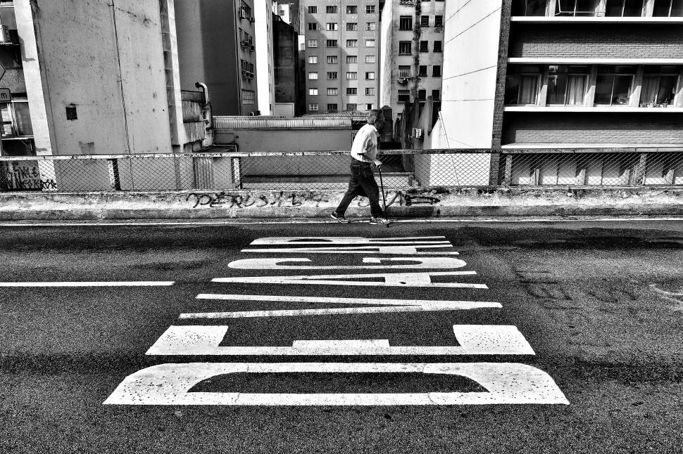 Free Image of Man walking across painted STOP sign 