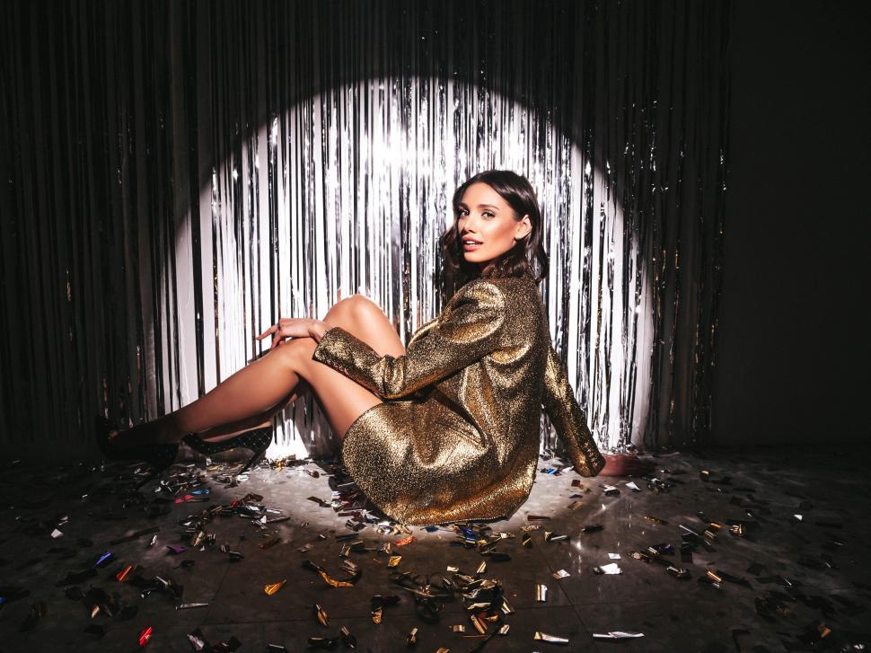Free Image of A woman sitting on the floor with confetti 