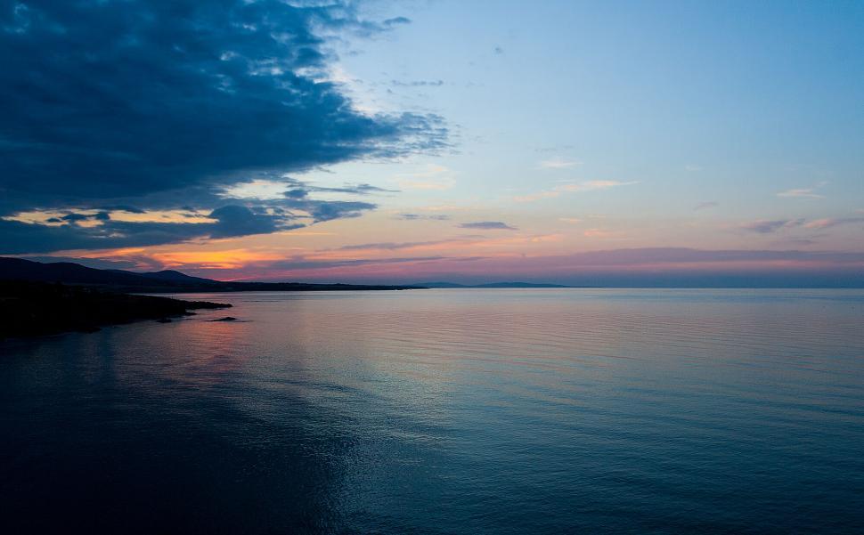 Free Image of Ocean sunset view with vibrant sky and coastline 