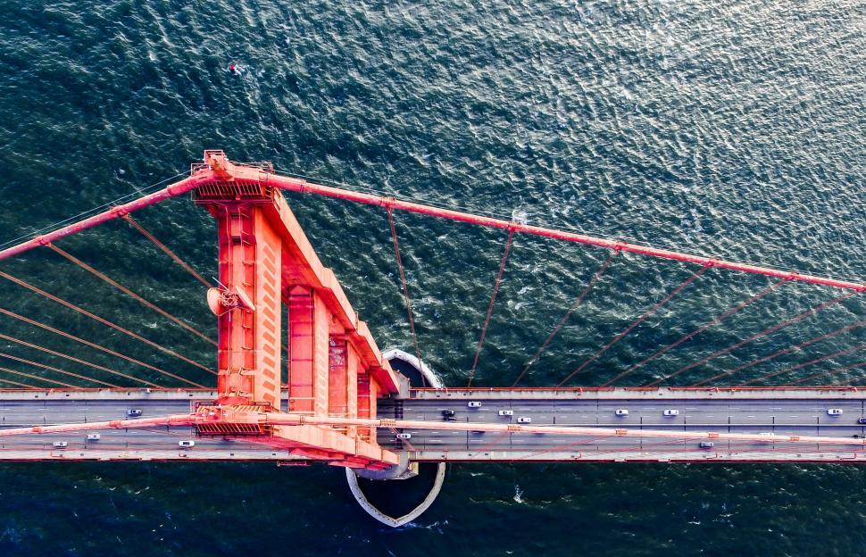 Free Image of Aerial view of a vibrant red bridge over water 