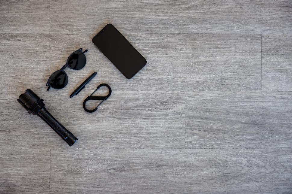 Free Image of Everyday carry items organized on wood floor 
