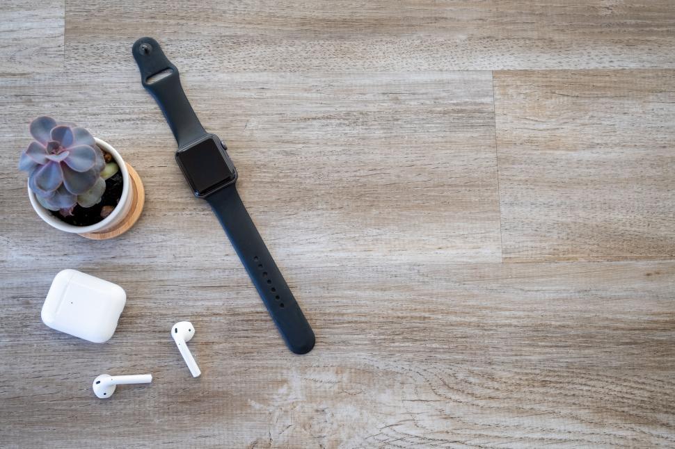 Free Image of Smartwatch and wireless earphones on wood 