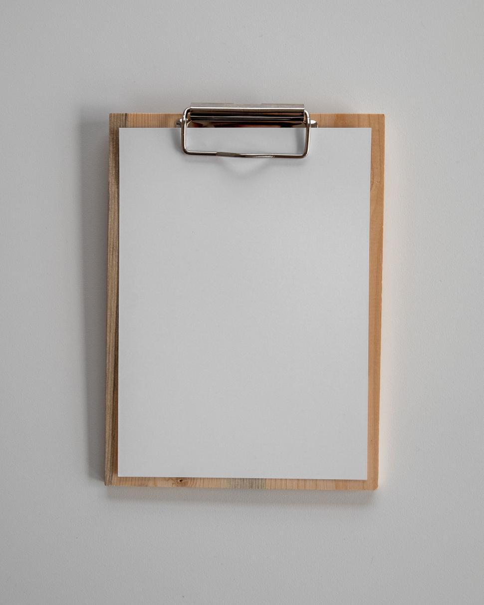 Free Image of Empty clipboard with white paper on wall 