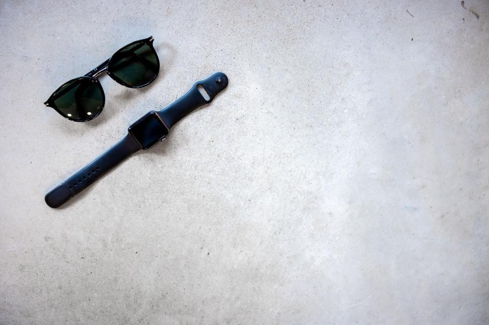 Free Image of Elegant watch and sunglasses on concrete 