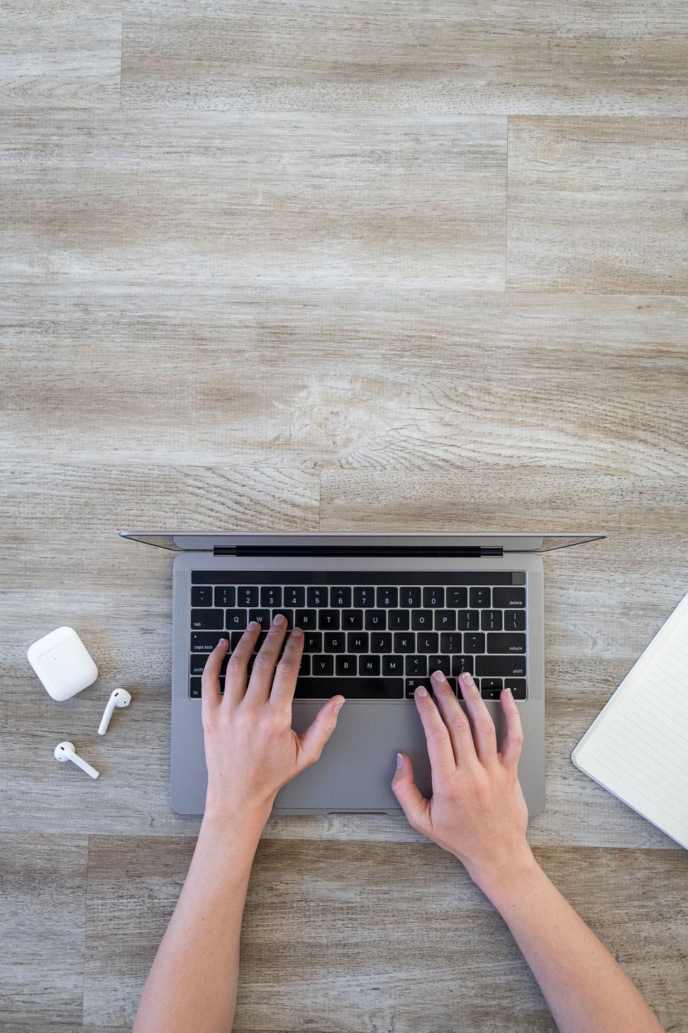 Free Image of Top view of hands typing on a laptop 