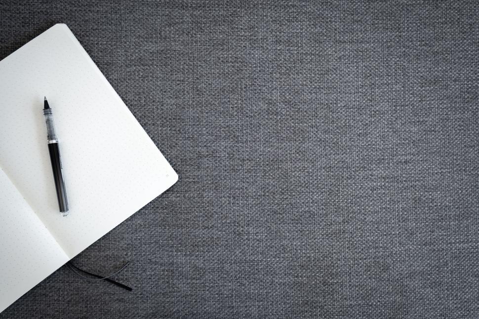 Free Image of Notebook and pen on grey textured background 
