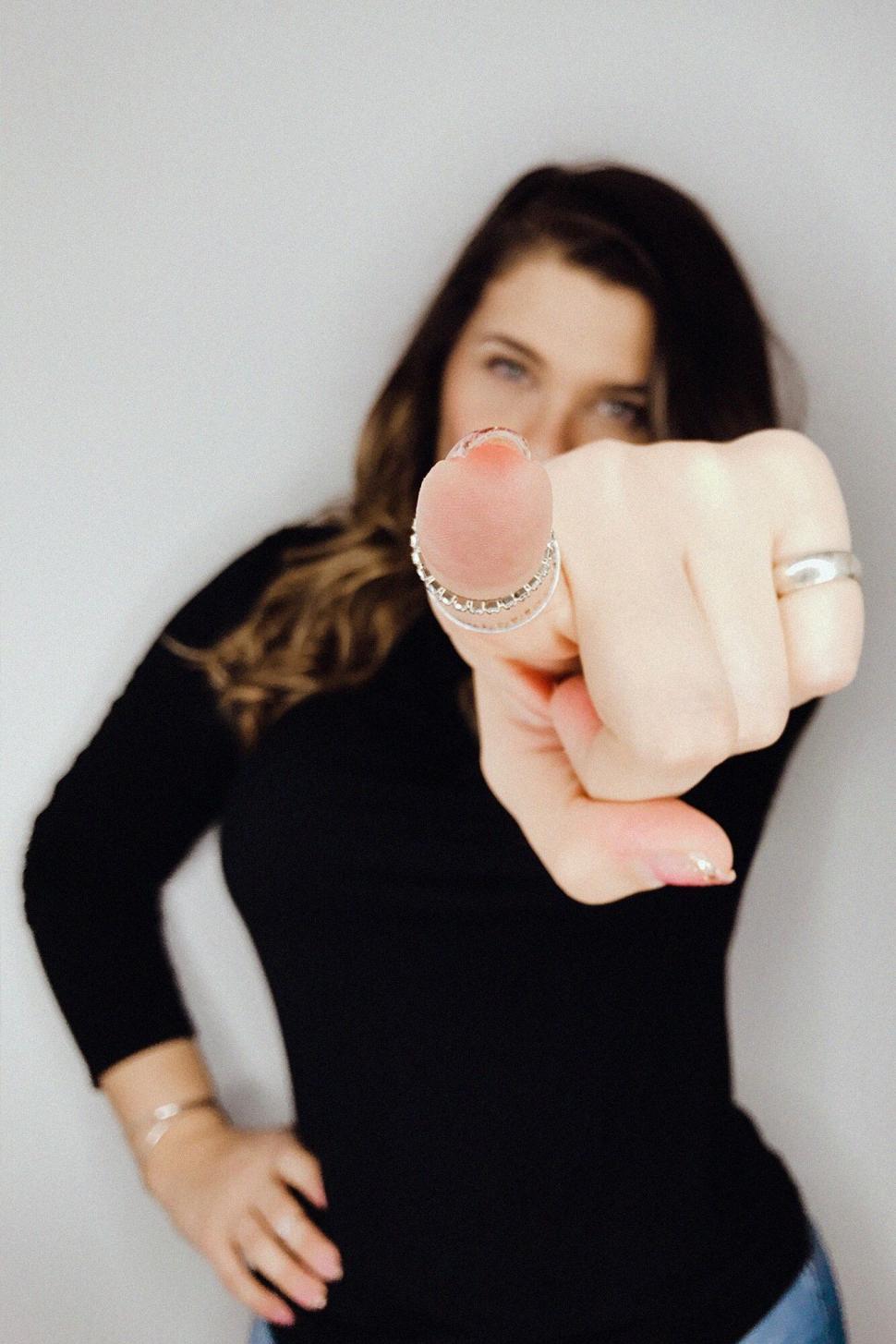 Free Image of Woman pointing at camera with focus on finger 