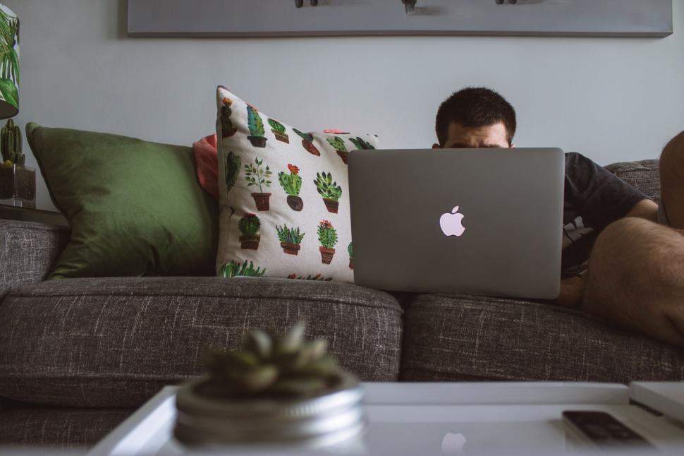 Free Image of Man working on laptop with blurred face 