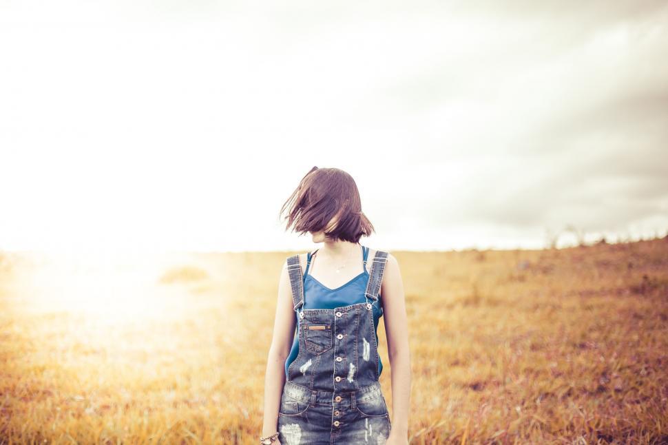 Free Image of Woman gazing towards sunlight in a field 