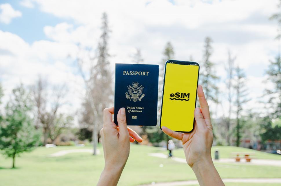 Free Image of A photo displaying a U.S. passport and a smartphone with an eSIM logo, symbolizing modern travel technology  