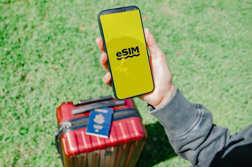 Free Image of A photo displaying a U.S. passport and a smartphone with an eSIM logo, symbolizing modern travel technology  