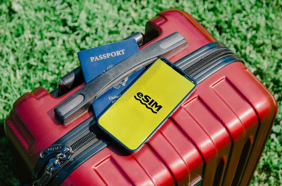 Free Image of A photo displaying a U.S. passport and a smartphone with an eSIM logo, symbolizing modern travel technology  