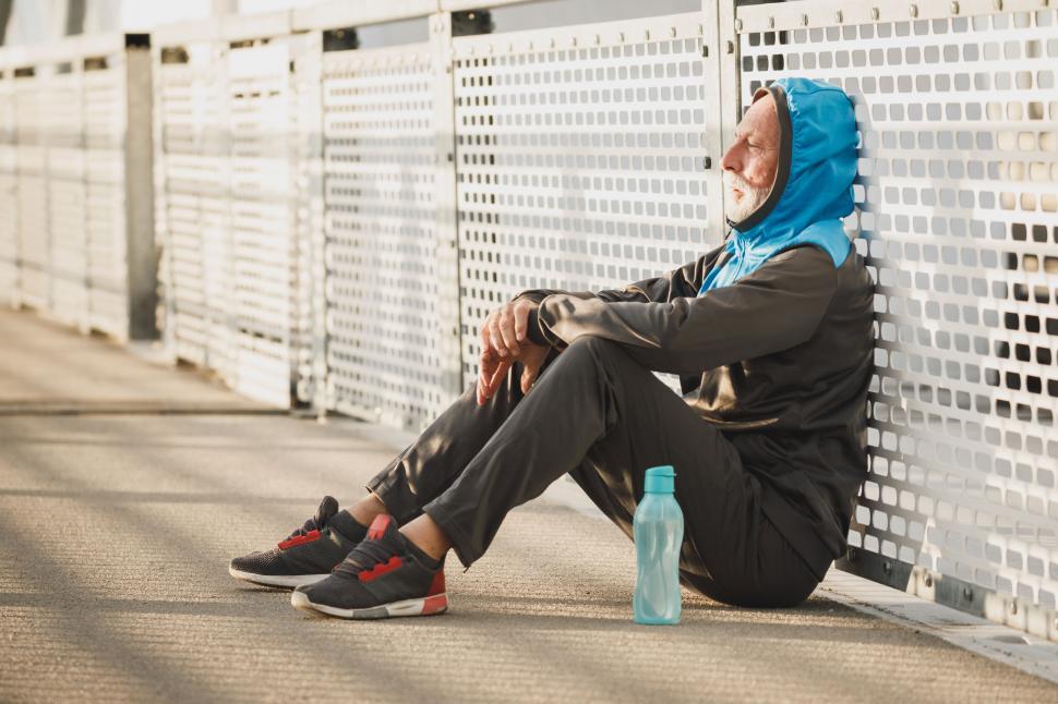 Free Image of Person sitting on a bridge after a workout 