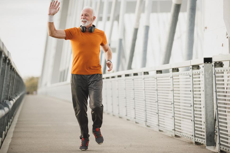 Free Image of Senior man jogging on a bridge 
