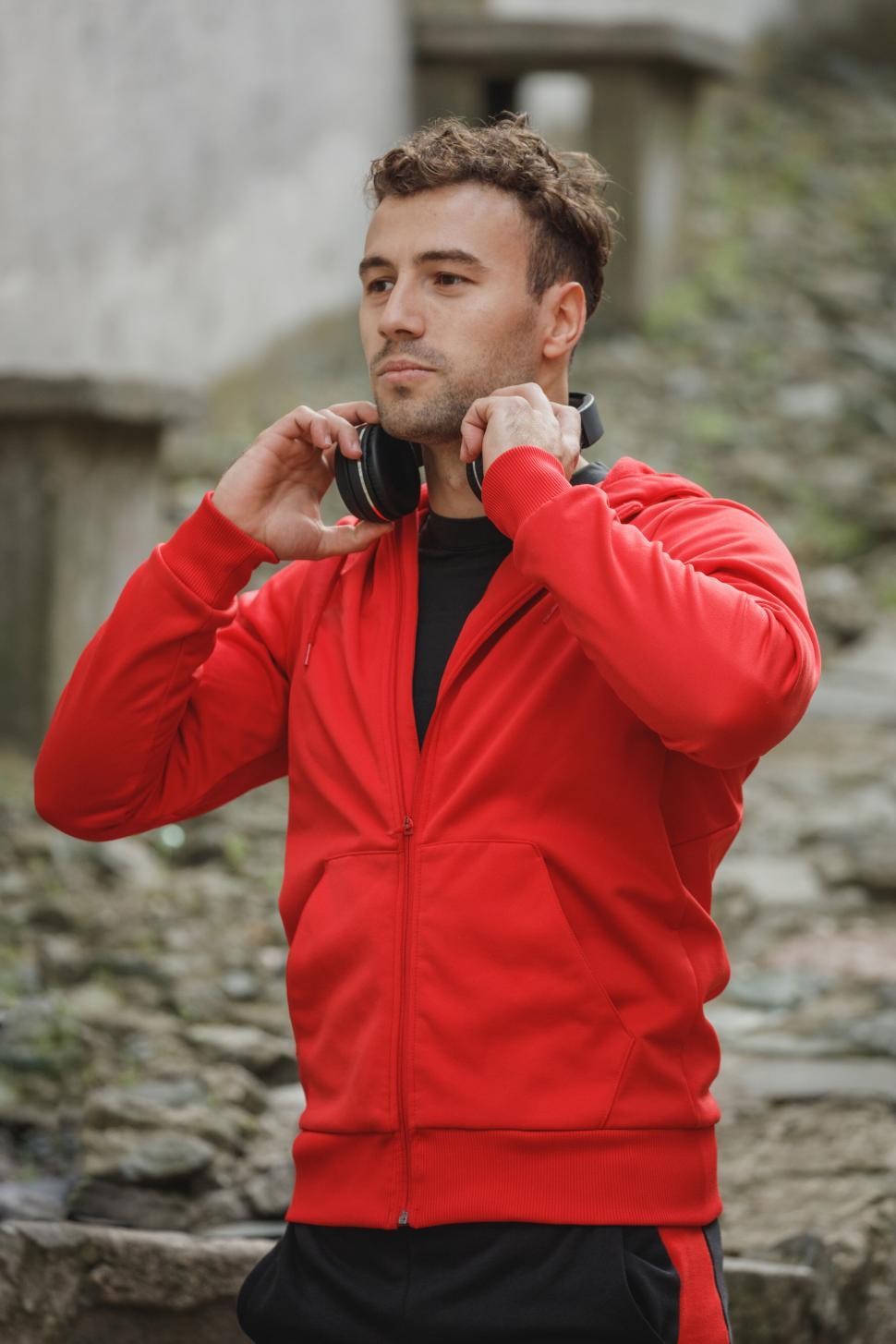 Free Image of Man putting on headphones outdoors 