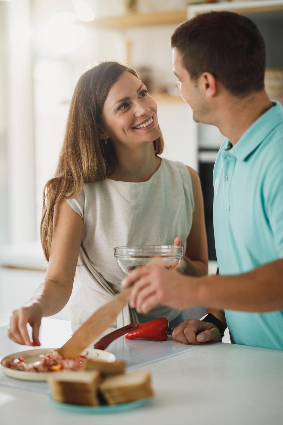 Free Image of Couple smiling while cooking in the kitchen 