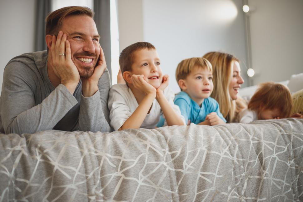 Free Image of Family watching something on bed together 