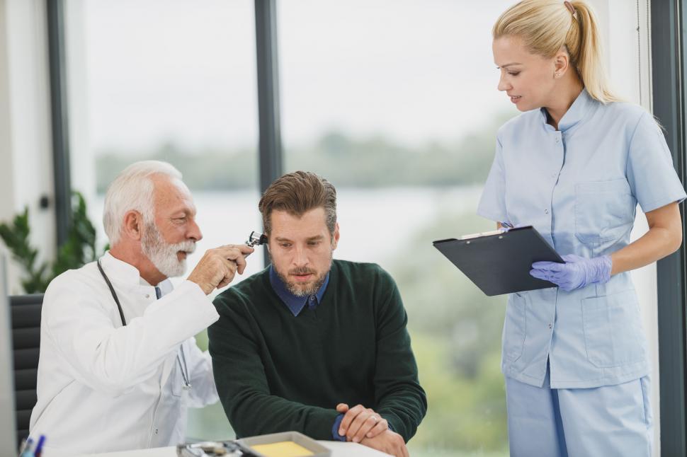 Free Image of Doctor examining patient with otoscope 