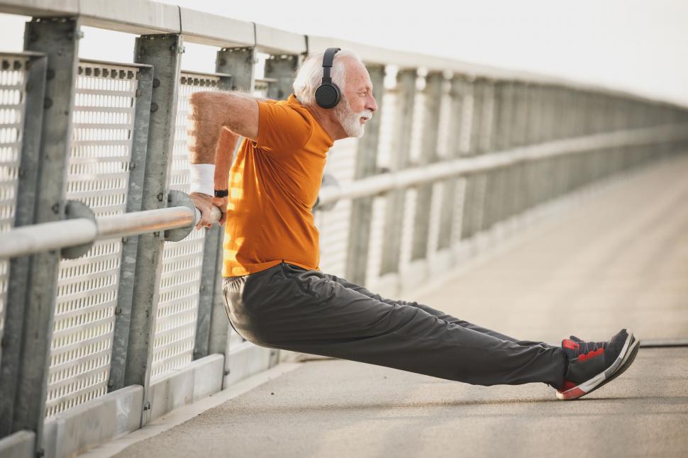 Free Image of Man relaxing legs on railing post workout 